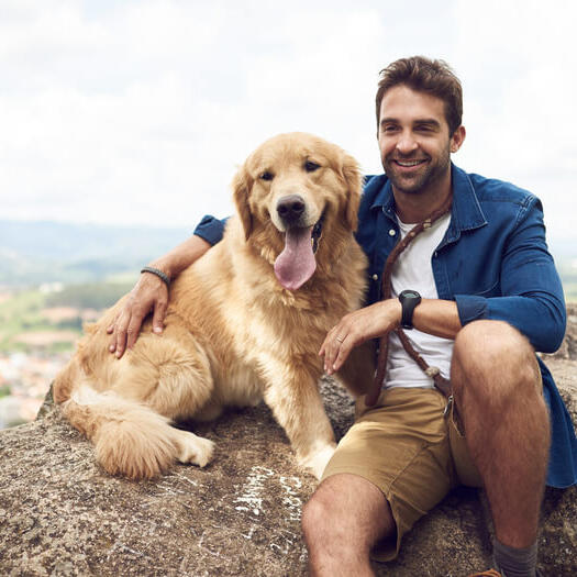 Man with golden retriever on the rock