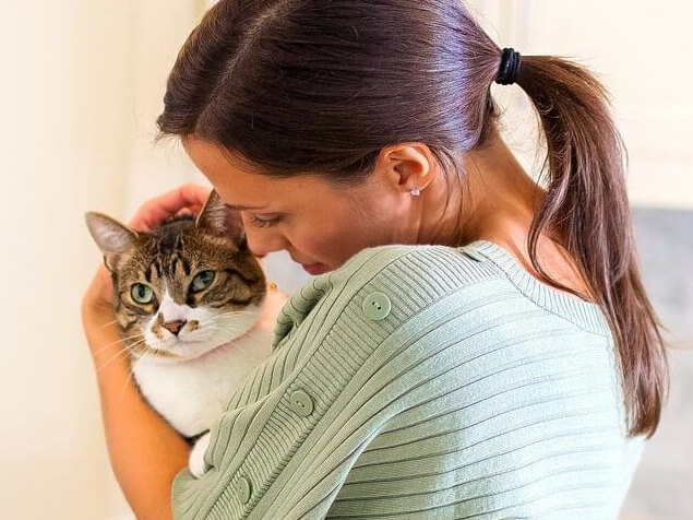 Woman cuddling cat