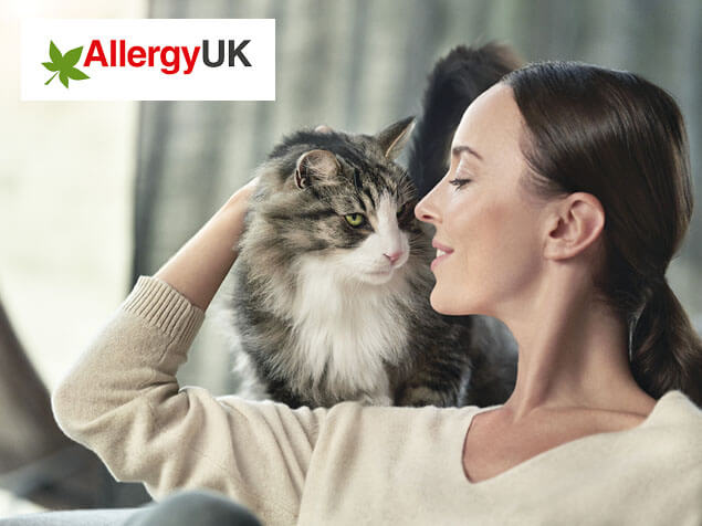 Allergy UK logo and cat on woman's shoulder