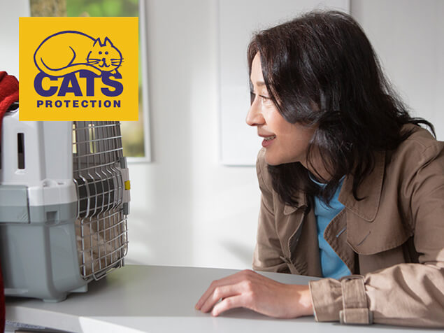 woman looking into cat carrier
