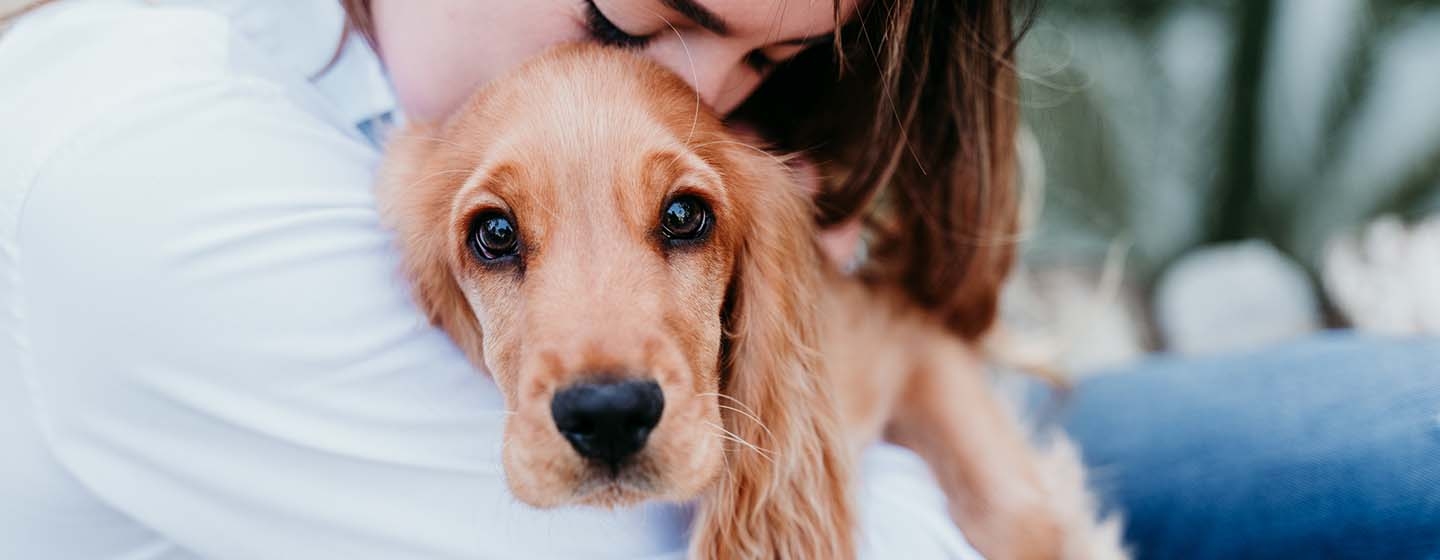 woman cuddling with dog
