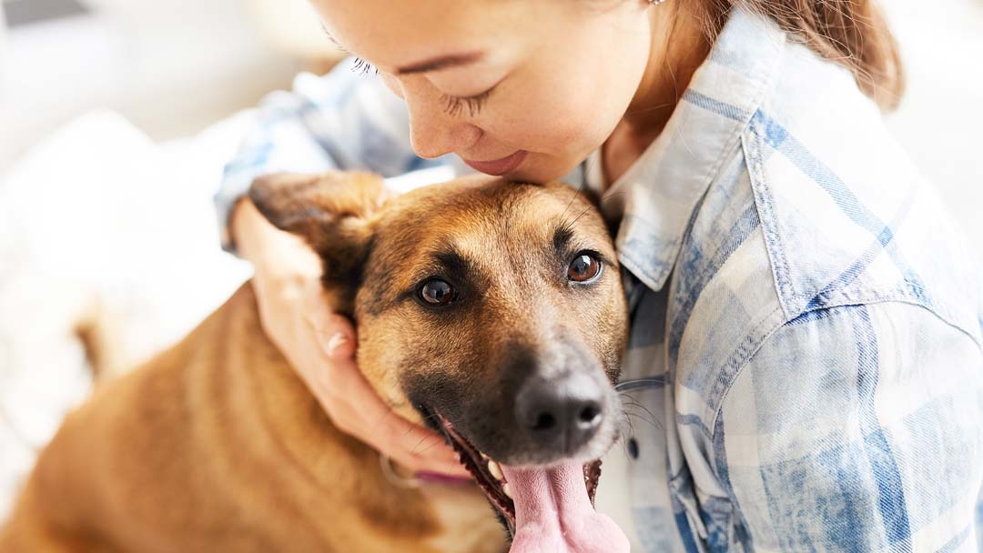 woman cuddling with dog