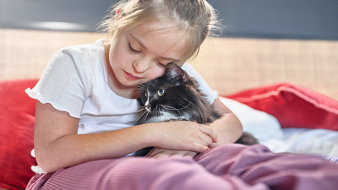 Young child cuddling cat