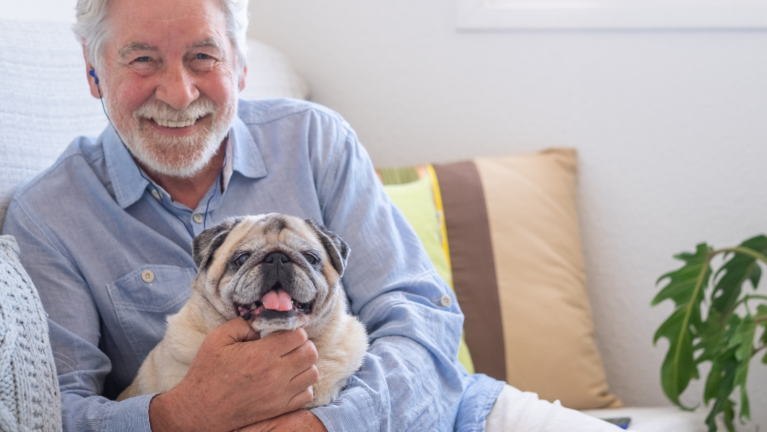 Man smiling and hugging his dog 