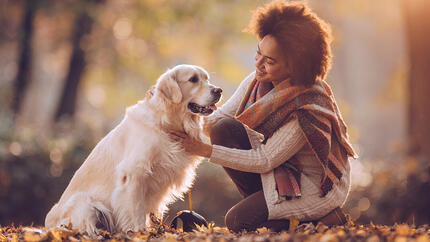 Woman sitting with dog in woods