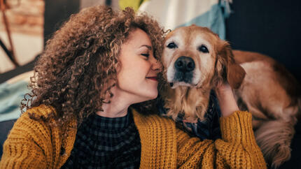 Woman cuddling old Golden Retriever