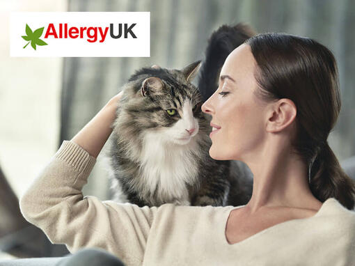 Allergy UK logo and cat on woman's shoulder