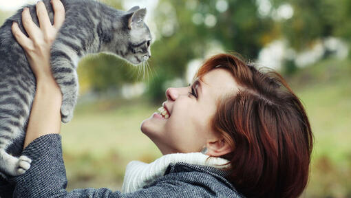 lady smiling and looking up at her cat