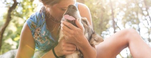 Young Woman cuddling her dog in the woods