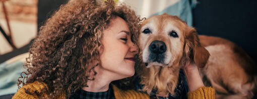 Woman cuddling old Golden Retriever