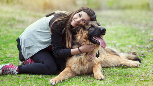 Woman hugging her German Shepherd in the Park