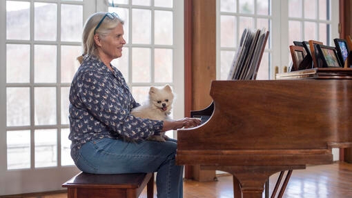 Dog listening to owner play the piano