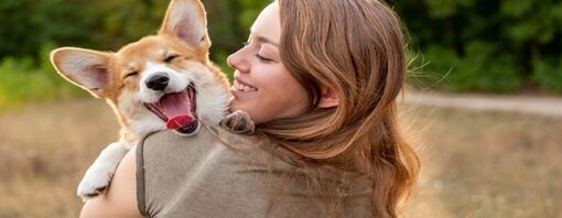 woman holding corgi smiling