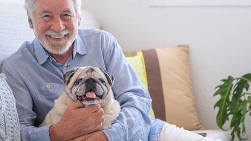 Man smiling and hugging his dog 