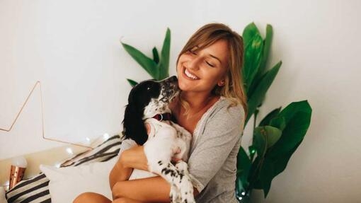 Woman holding her dog sitting down  