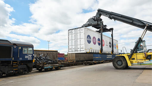 A loader putting a Nestle container onto a freight train