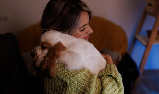 Woman hugging scared dog