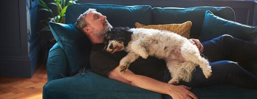 man on sofa with dog