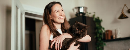 Young woman holding a cat in her arms