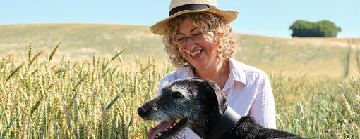 Farmer sat in a corn field with her dog