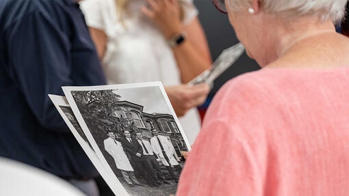 Member of Bakers family looking at a black and white photograph