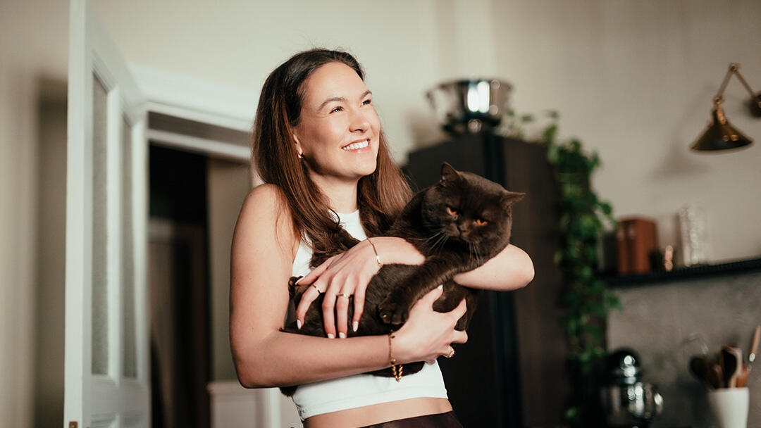 Young woman holding a cat in her arms