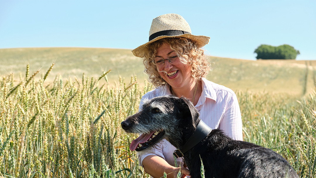 Farmer sat in a corn field with her dog